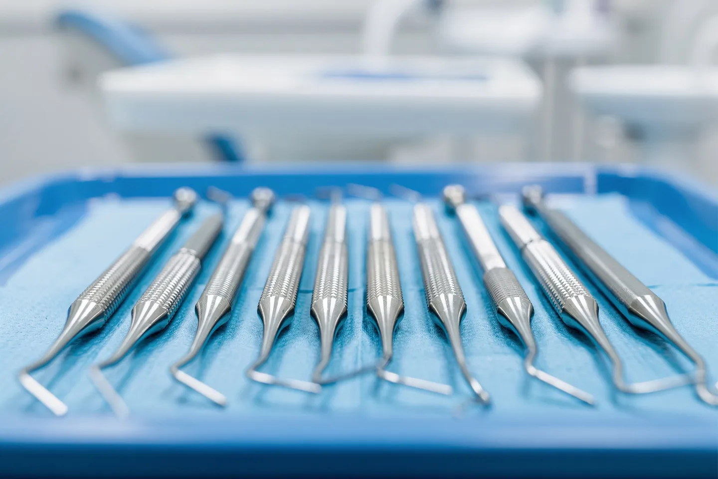 Präzise Zahnarztinstrumente liegen ordentlich auf einem sterilen blauen Tablett
