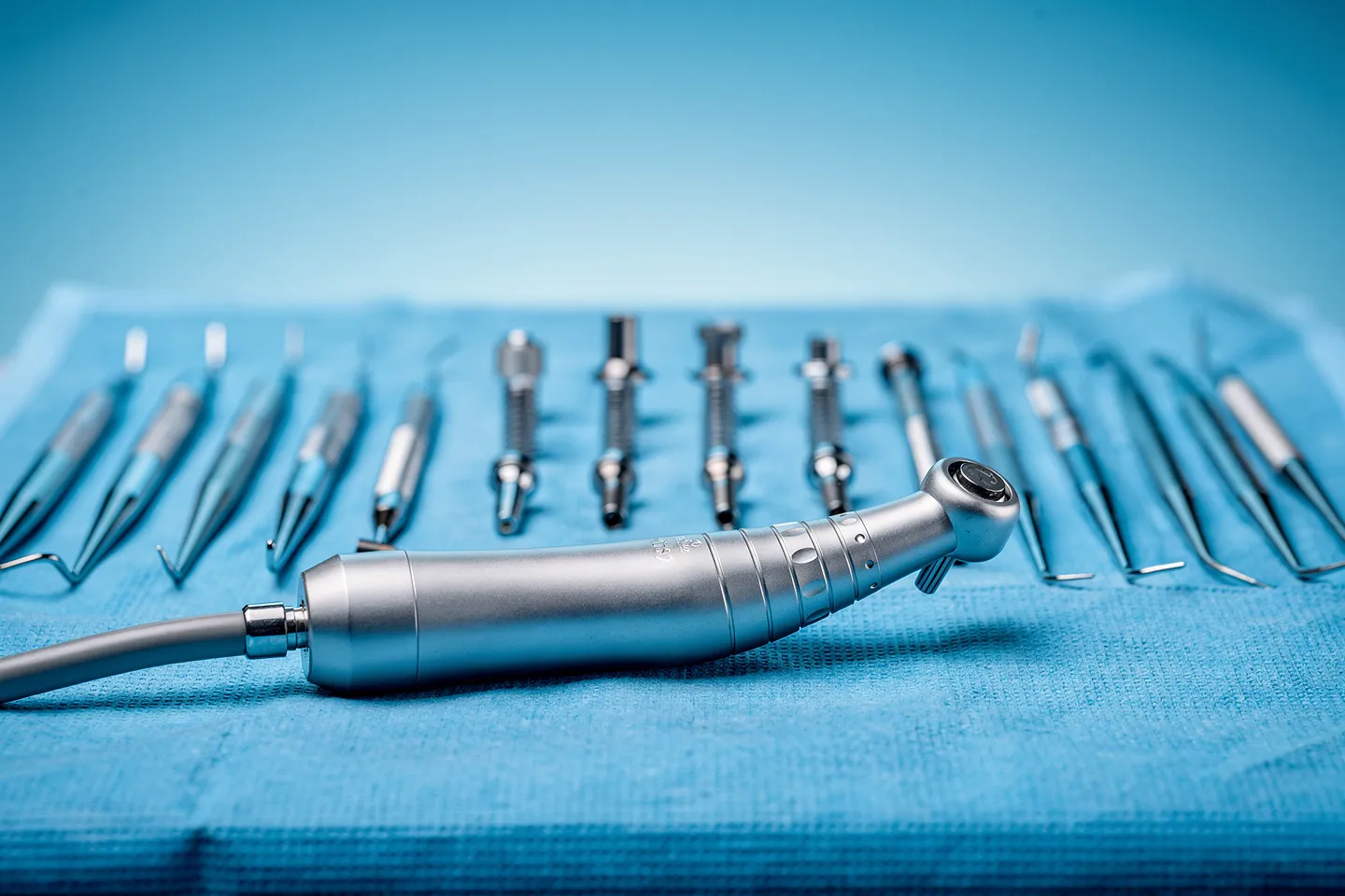 Präzise Zahnarztinstrumente liegen ordentlich auf einem sterilen blauen Tuch