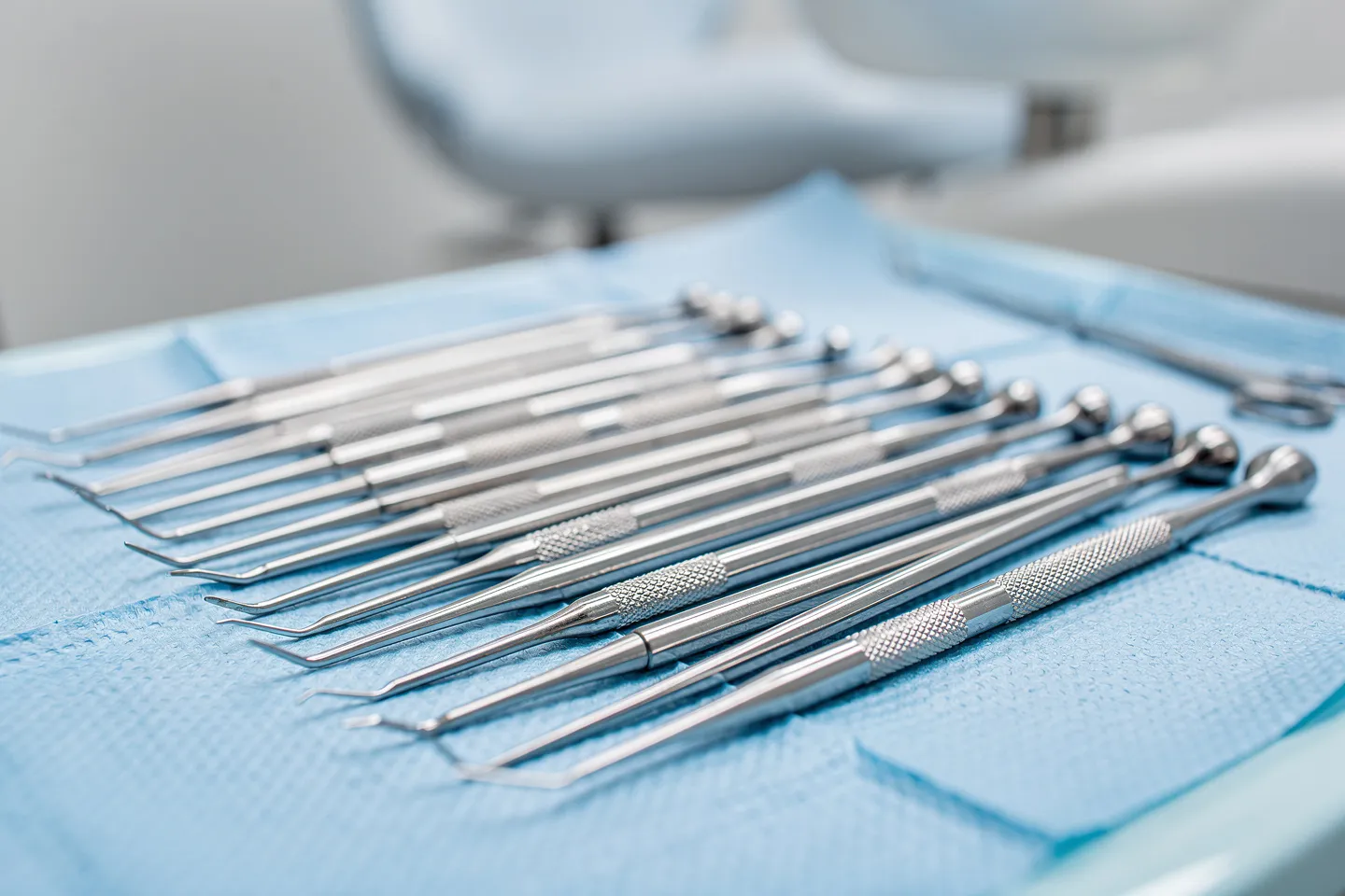 Sterile chirurgische Zahninstrumente liegen ordentlich auf einem blauen Tablett