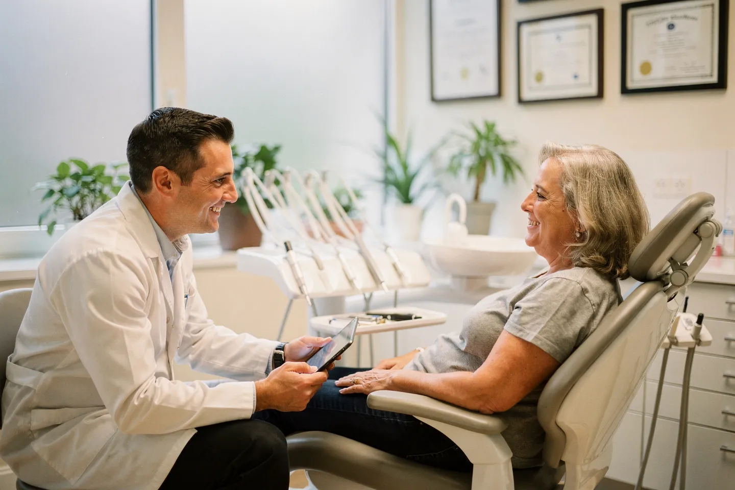 Ein freundlicher Zahnarzt bespricht Behandlungsoptionen mit einem Patienten in einer modernen Praxis