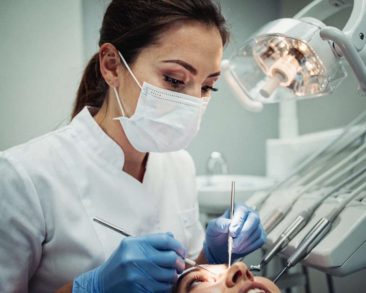Eine Zahnärztin führt mit Präzisionsinstrumenten eine Behandlung am Patienten durch