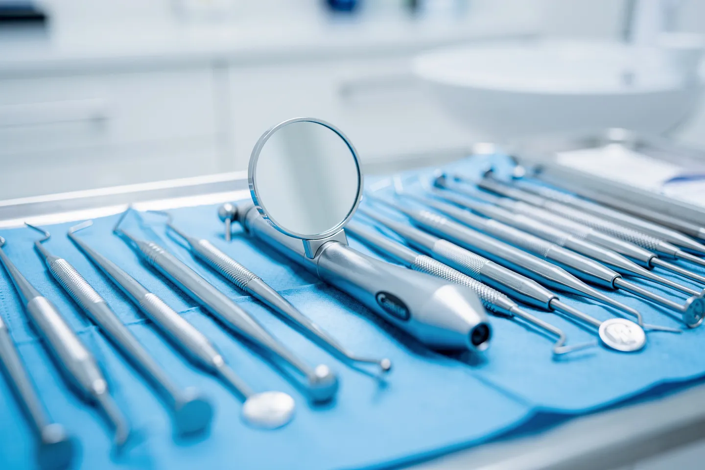 Präzisions-Zahnarztinstrumente ordentlich auf einem sterilen blauen Tablett angeordnet