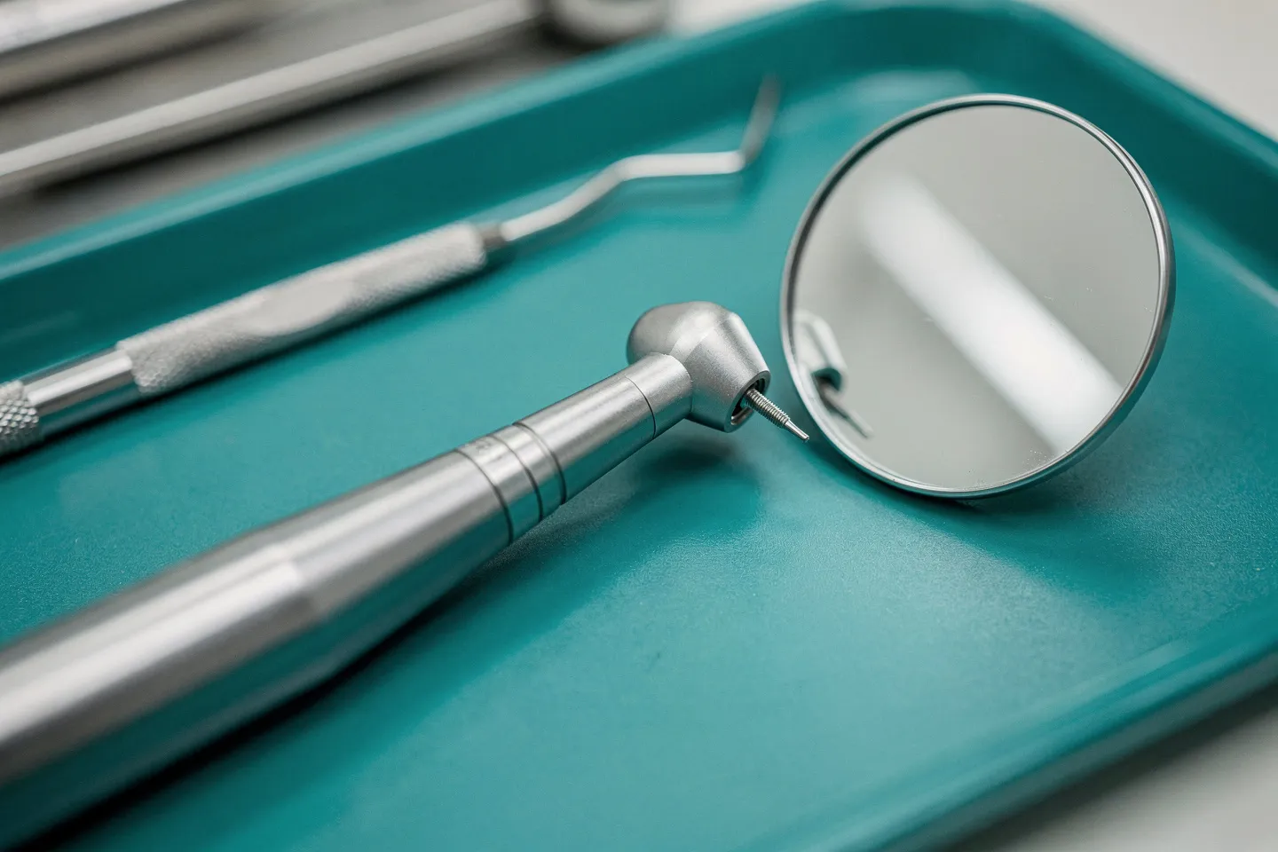 Hochglanzpolierte Zahnarztinstrumente auf einem sterilen blaugrünen Tablett