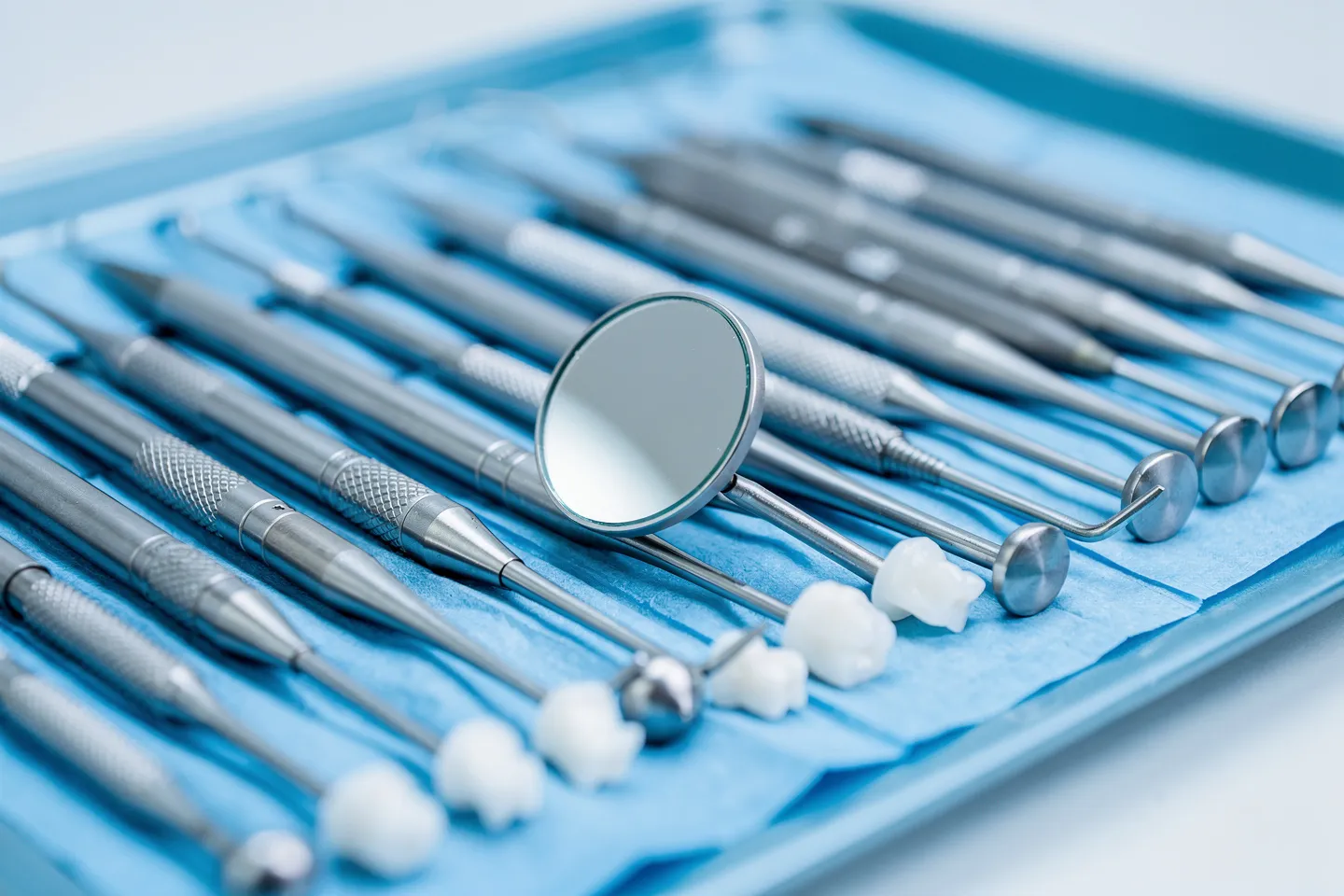 Präzisions-Zahnarztinstrumente auf blauem sterilen Tablett mit Spiegelreflexion