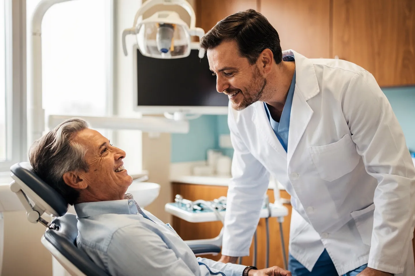 Ein freundlicher Zahnarzt berät einen lächelnden Patienten in einer modernen Praxis