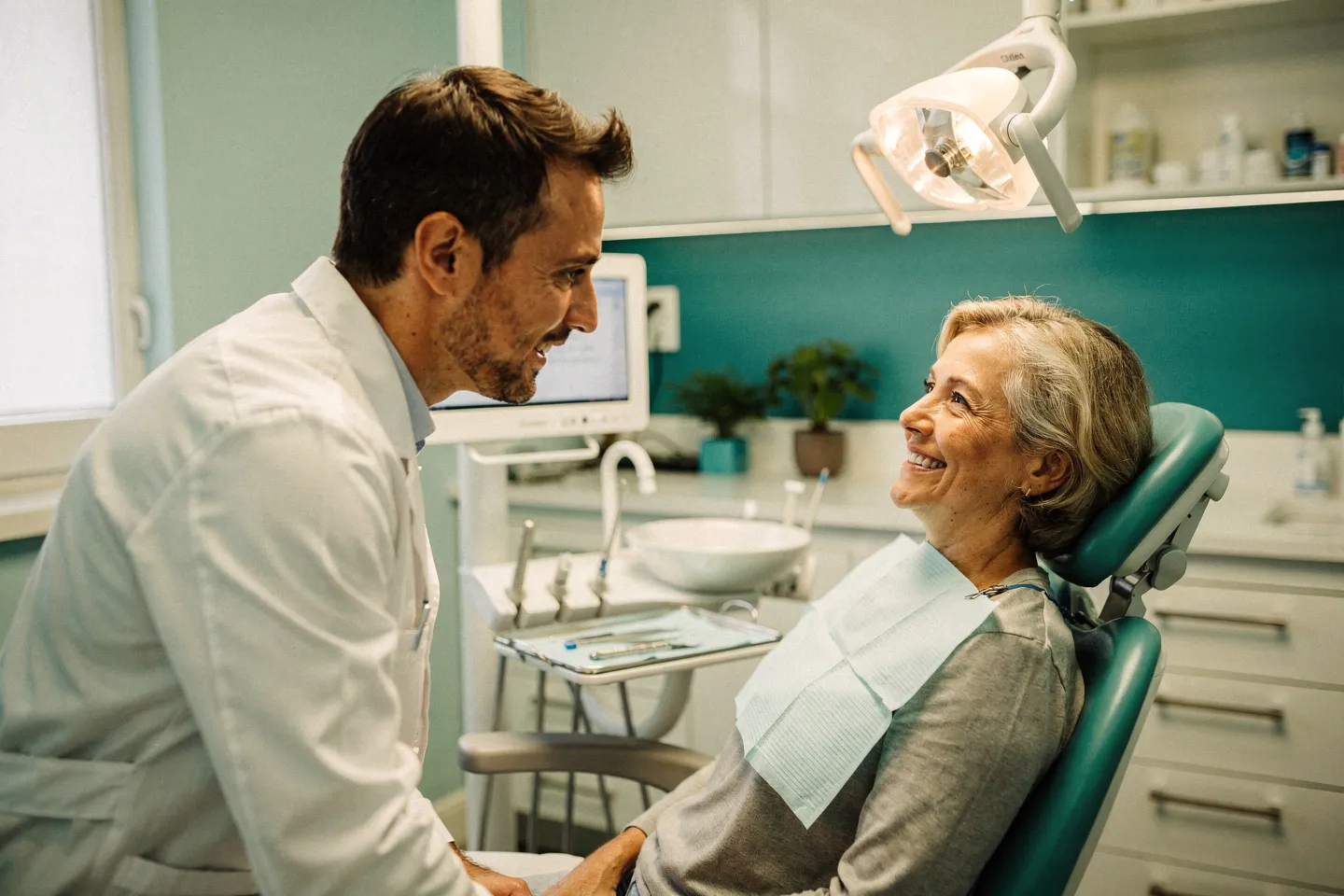 Ein freundlicher Zahnarzt berät einen lächelnden Patienten in einer modernen Zahnarztpraxis