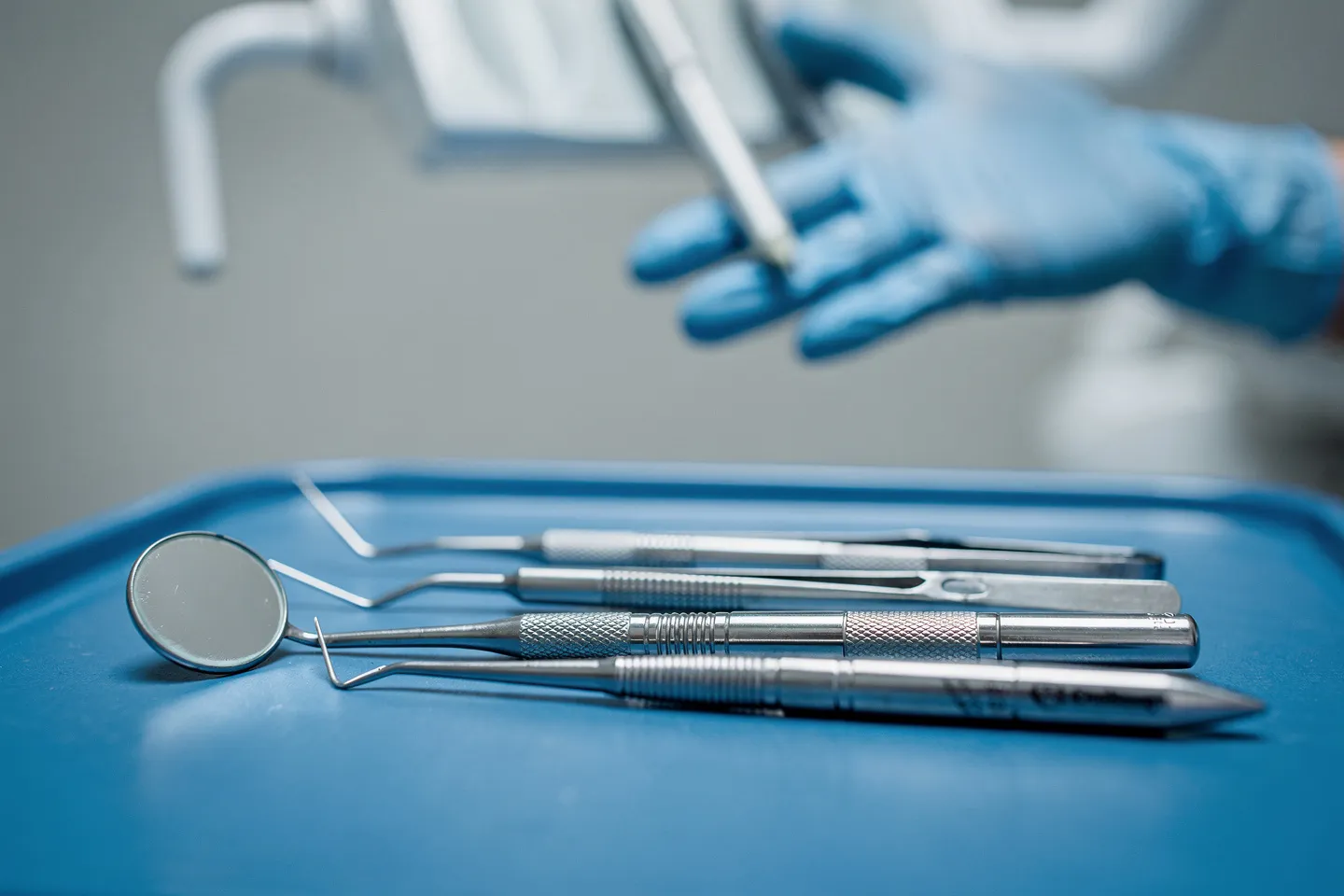 Präzise Zahnarztinstrumente liegen ordentlich auf einem blauen sterilen Tablett
