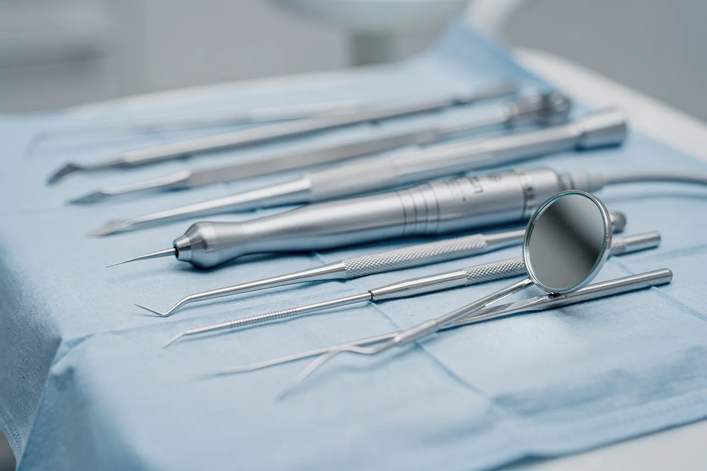 Präzisions-Zahnarztwerkzeuge liegen ordentlich auf einem sterilen blauen Tuch arrangiert