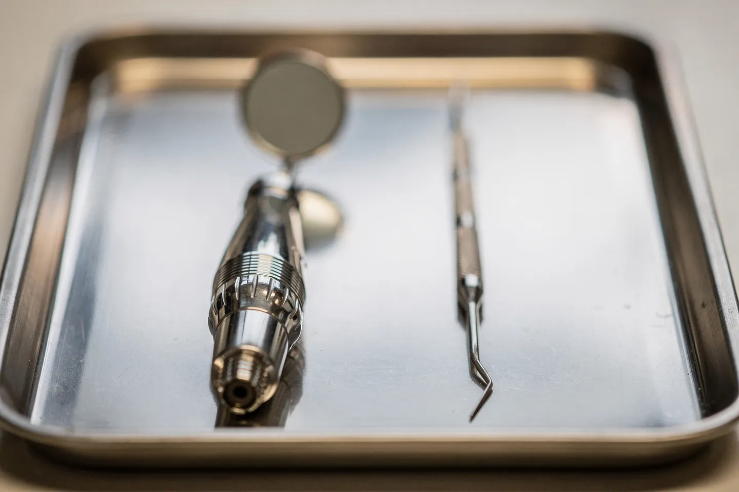 Präzisions-Zahnarztinstrumente symmetrisch auf einem sterilen Edelstahltablett angeordnet