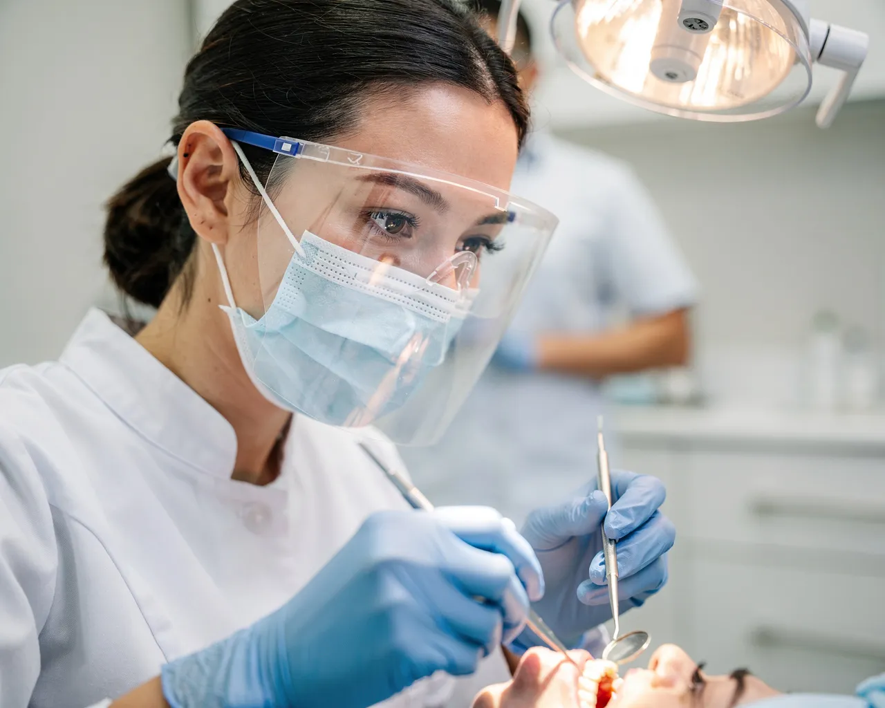 Eine Zahnärztin führt mit Präzision eine Behandlung durch, während sie Instrumente hält