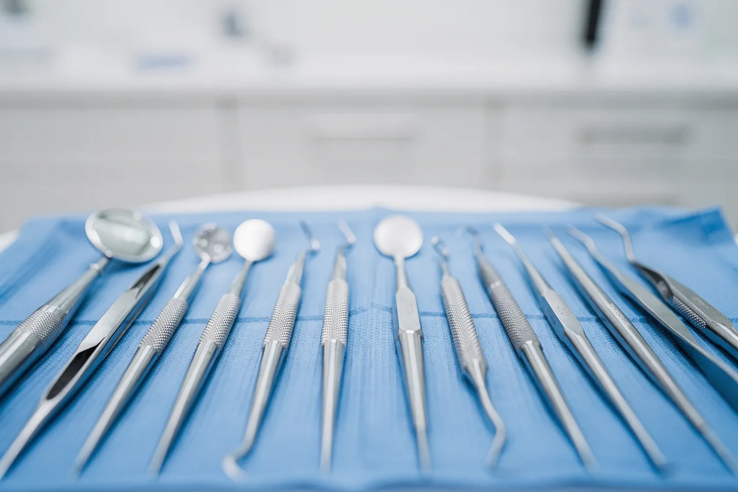 Präzise Zahnarztinstrumente liegen ordentlich auf einem blauen sterilen Tablett