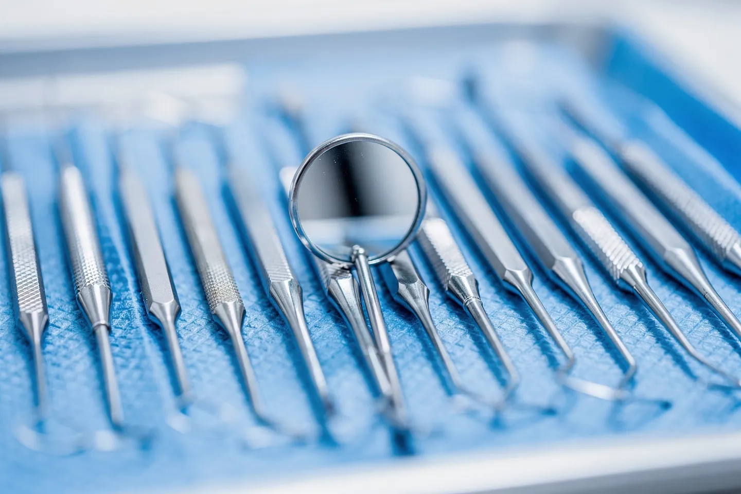 Präzisions-Zahnarztinstrumente ordentlich auf einem sterilen blauen Tablett angeordnet