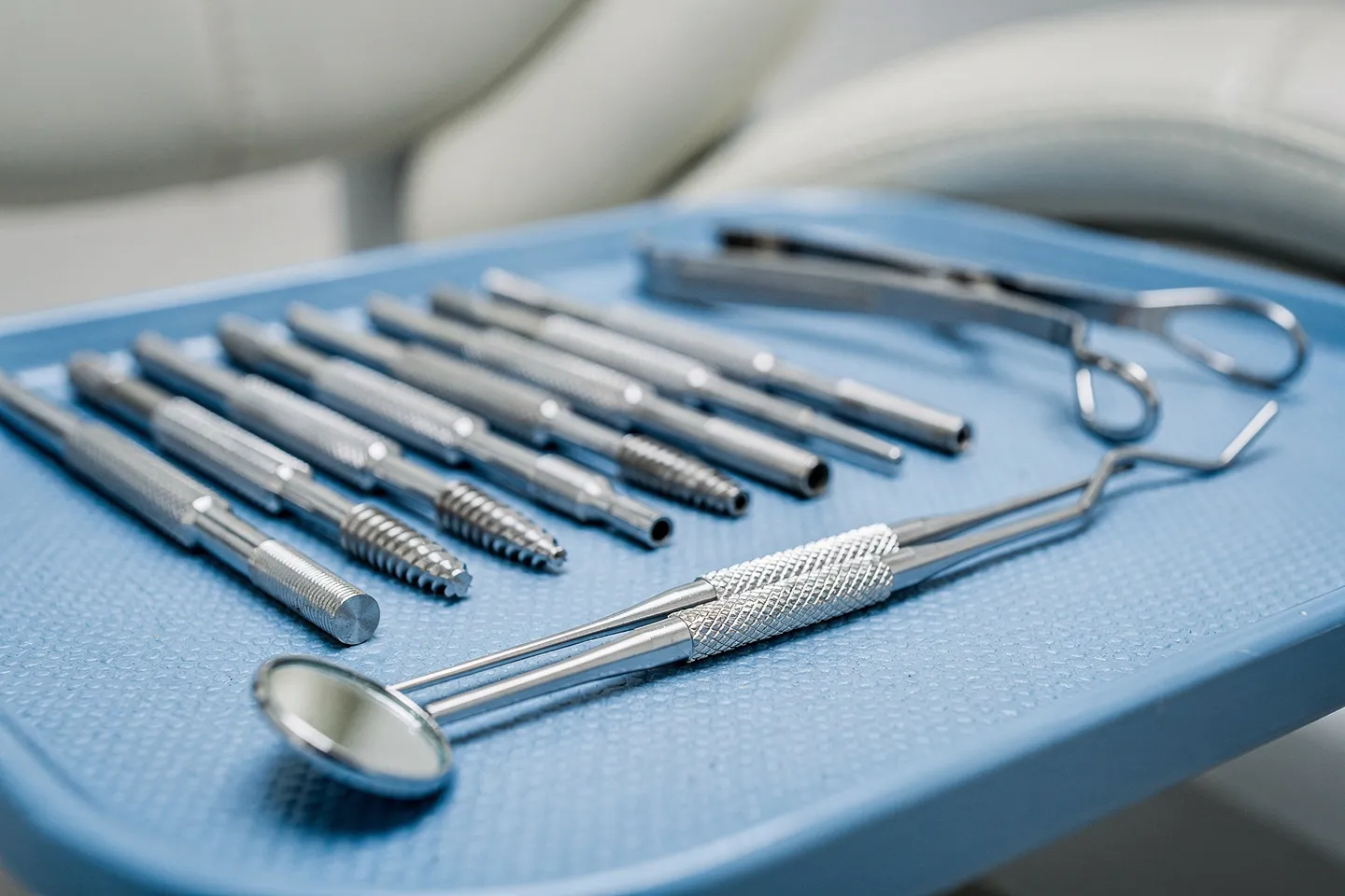 Präzisions-Zahnarztinstrumente ordentlich auf einem sterilen blauen Tablett angeordnet