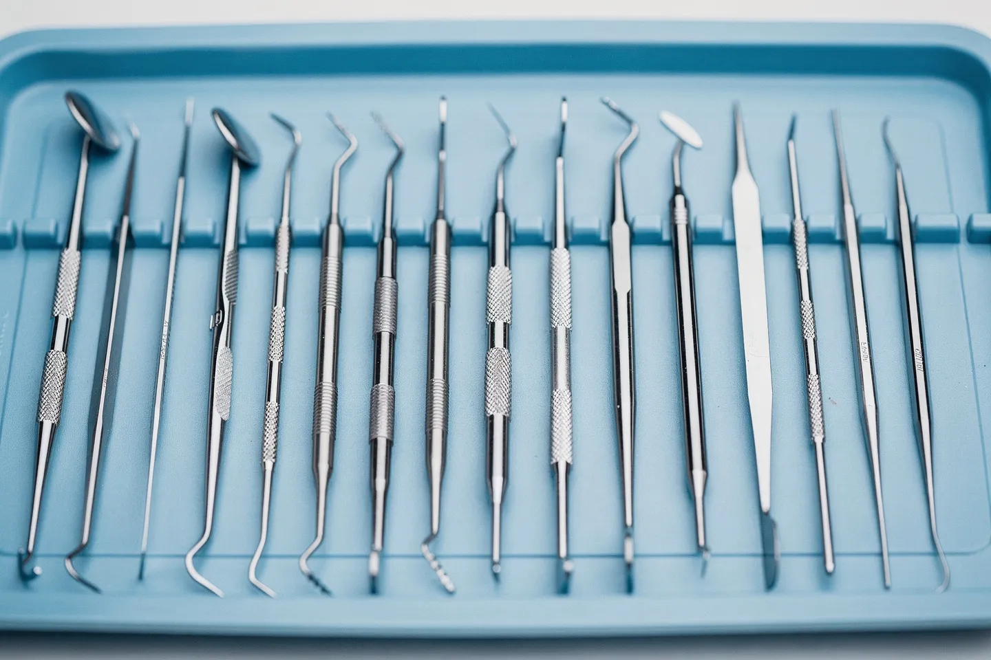 Präzise Zahnarztinstrumente liegen ordentlich auf einem blauen sterilen Tablett