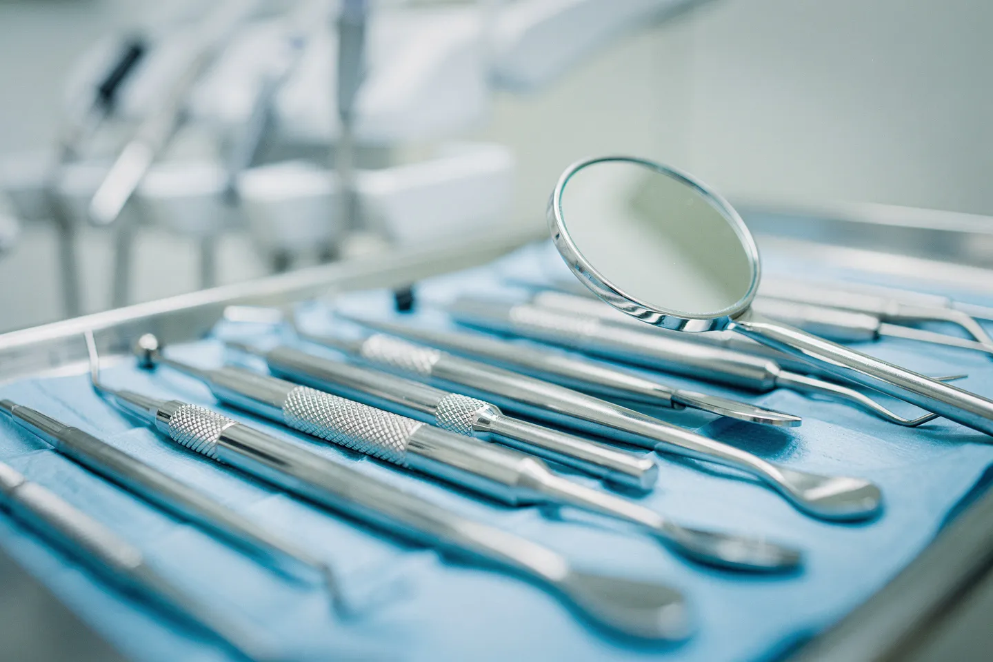 Präzise Zahnarztinstrumente liegen ordentlich auf einem blauen sterilen Tablett