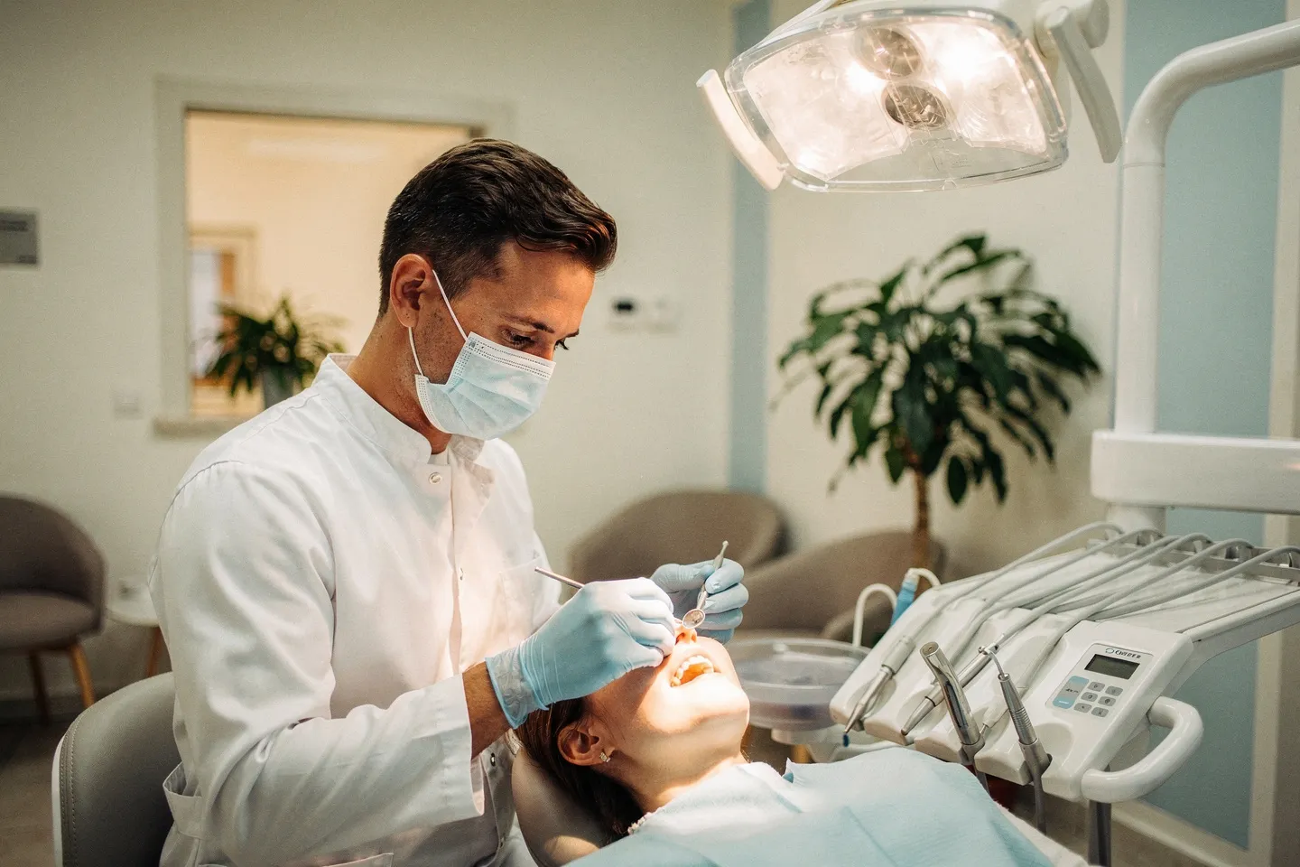 Ein Zahnarzt untersucht einen Patienten in einer modernen Zahnarztpraxis mit sauberer Ausstattung